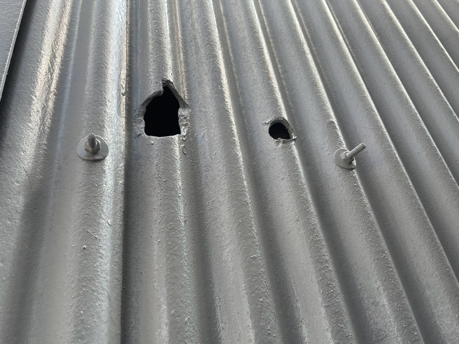 塗装中の波型スレートの穴